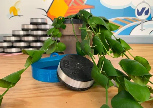 Photo sur un bureau de notre gyrophare devops connecté Blinky utilisé sur notre service SaaS, recouvert par une plante